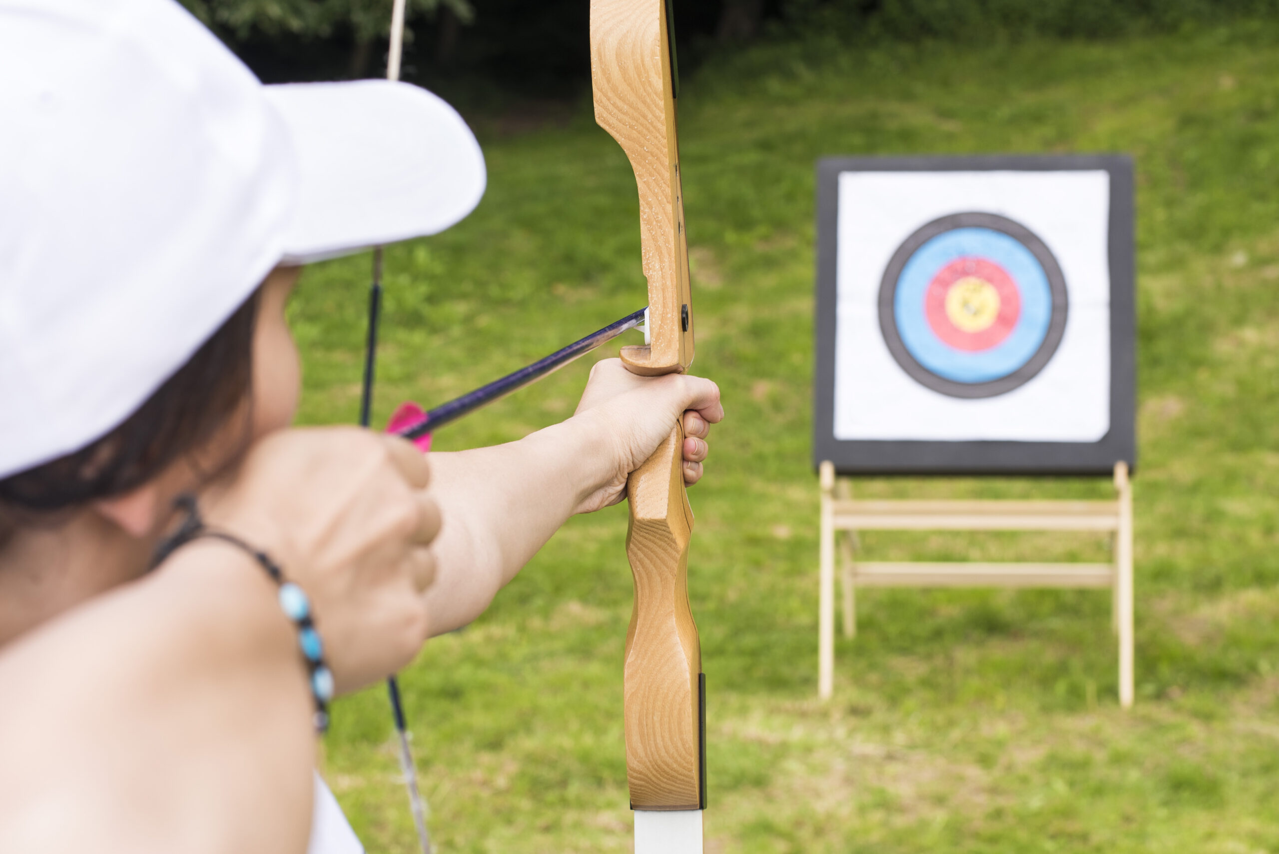 young-female-archer-holding-his-bow-aiming-target-sport-recreation-concept-scaled.jpg